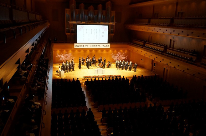 グリーンハウス、東京フィルハーモニー交響楽団による伴奏で、壇上の役員と新入社員が社歌を斉唱