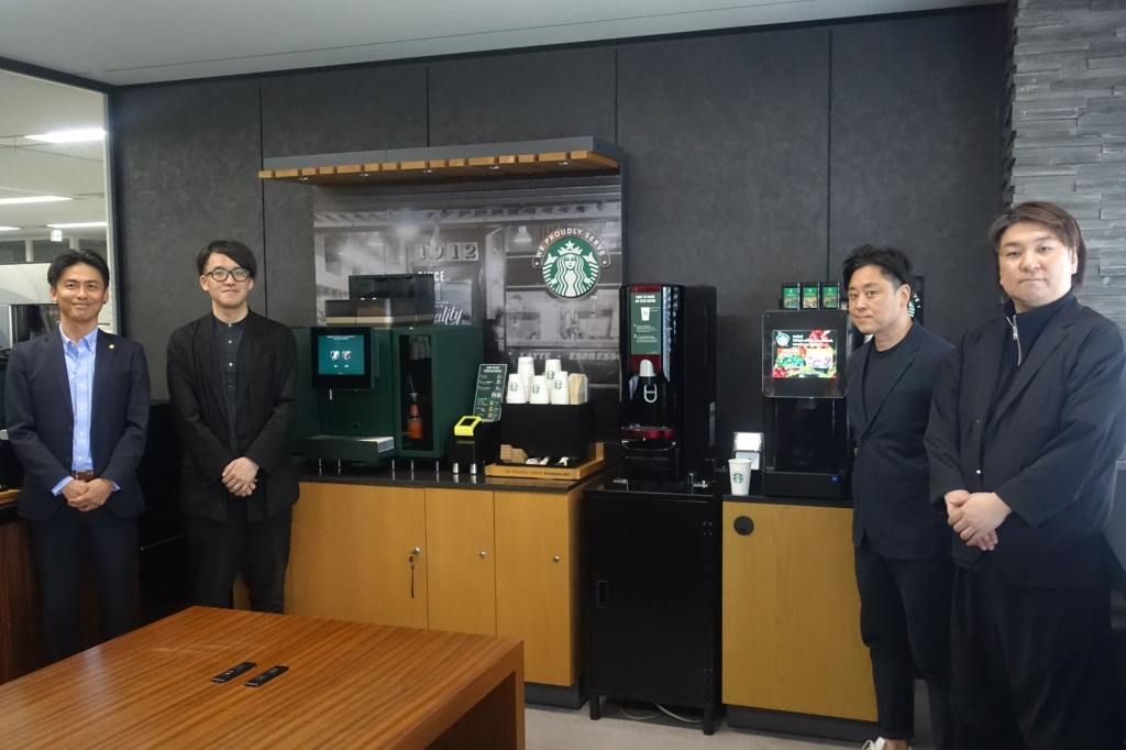 新マシンを囲む登壇者(左から)ネスレ日本 橋本部長、イトーキ 岡氏、コクヨ 青木氏、丹青社 安元氏