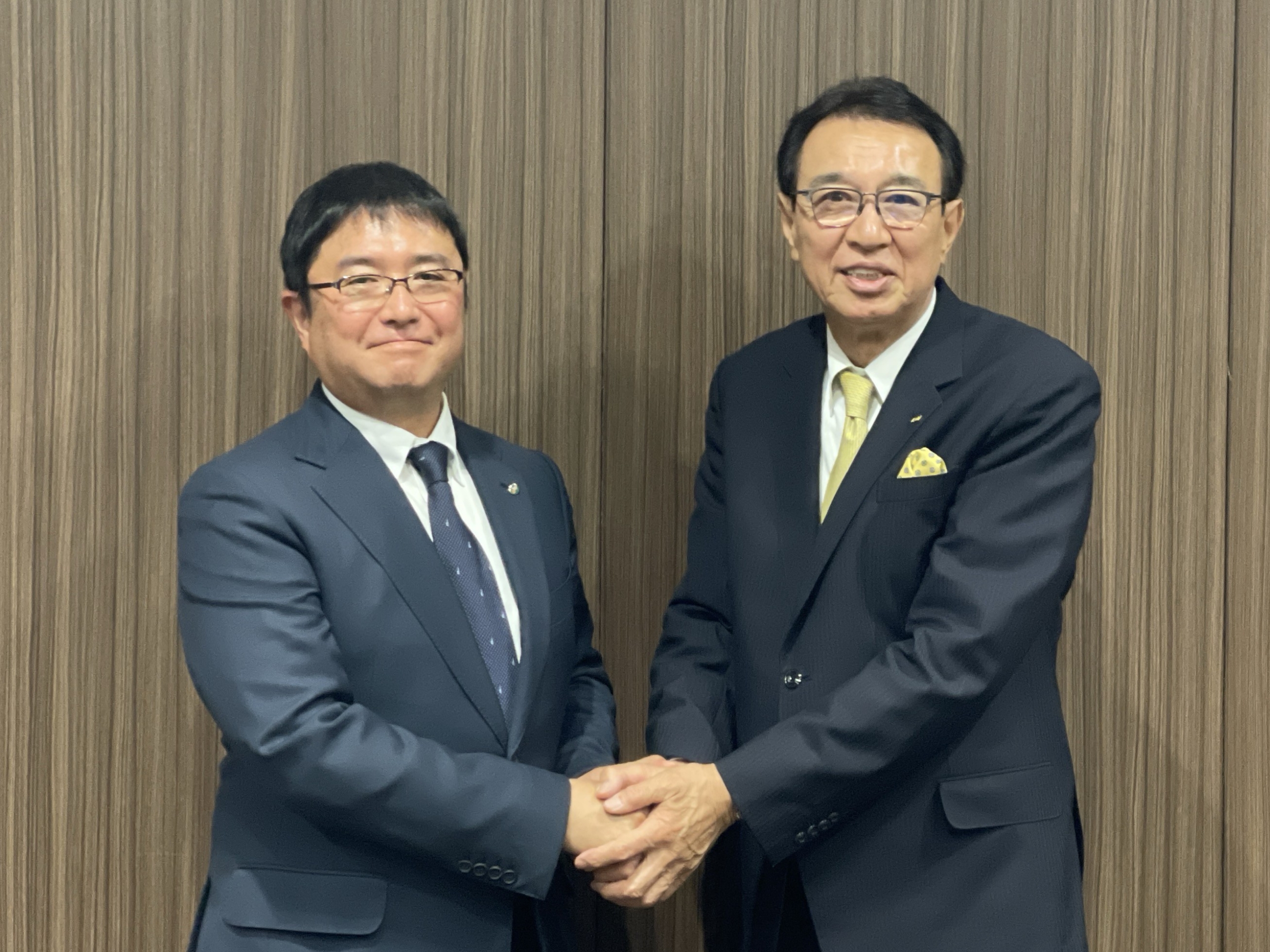 握手を交わす馬渕新会長(左)と西脇前会長