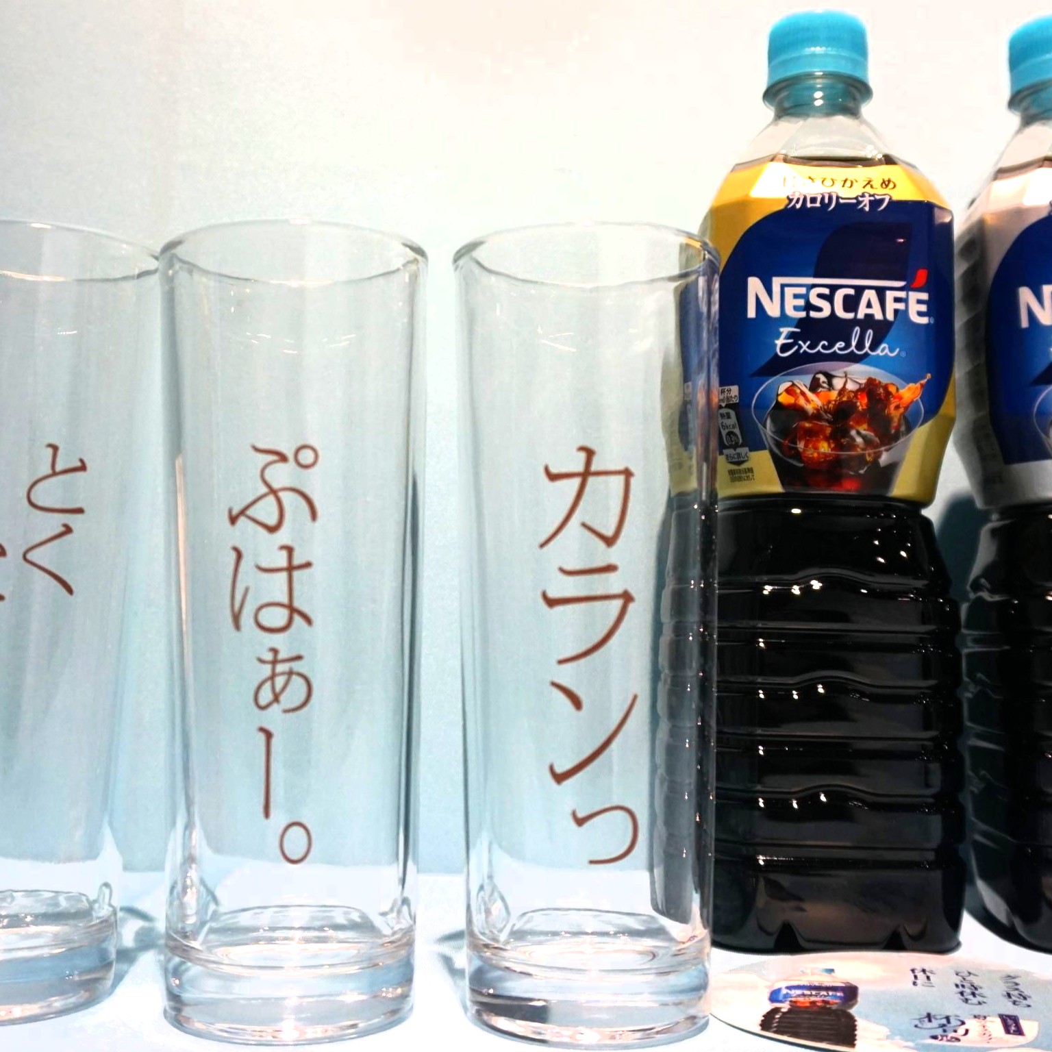 擬音語のフレーズがデザインされたグラスでアイスコーヒーが提供される