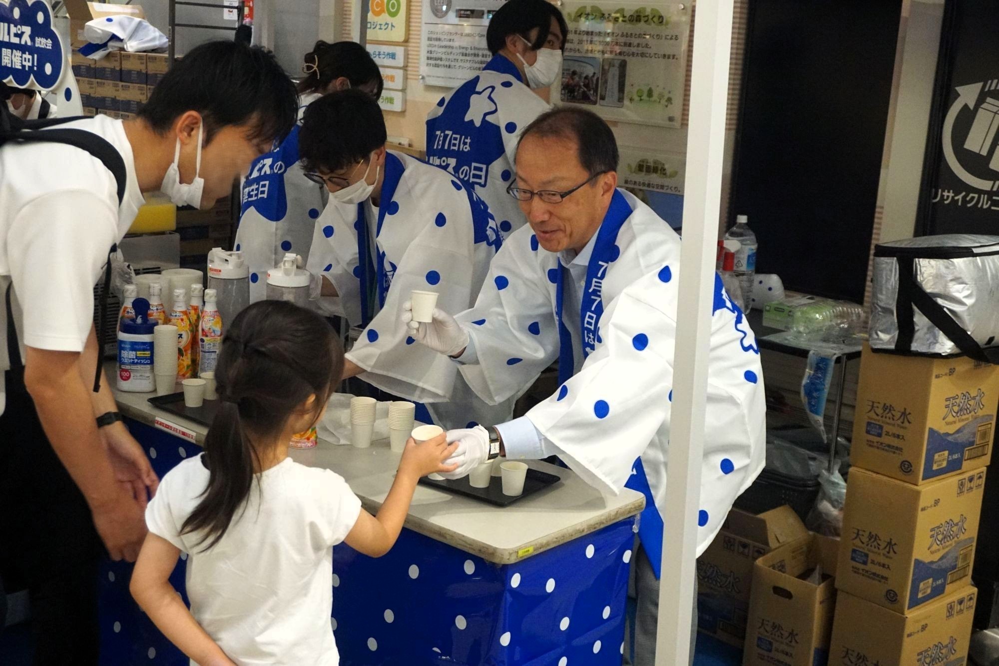 米女社長が来店客にサンプリングをする様子