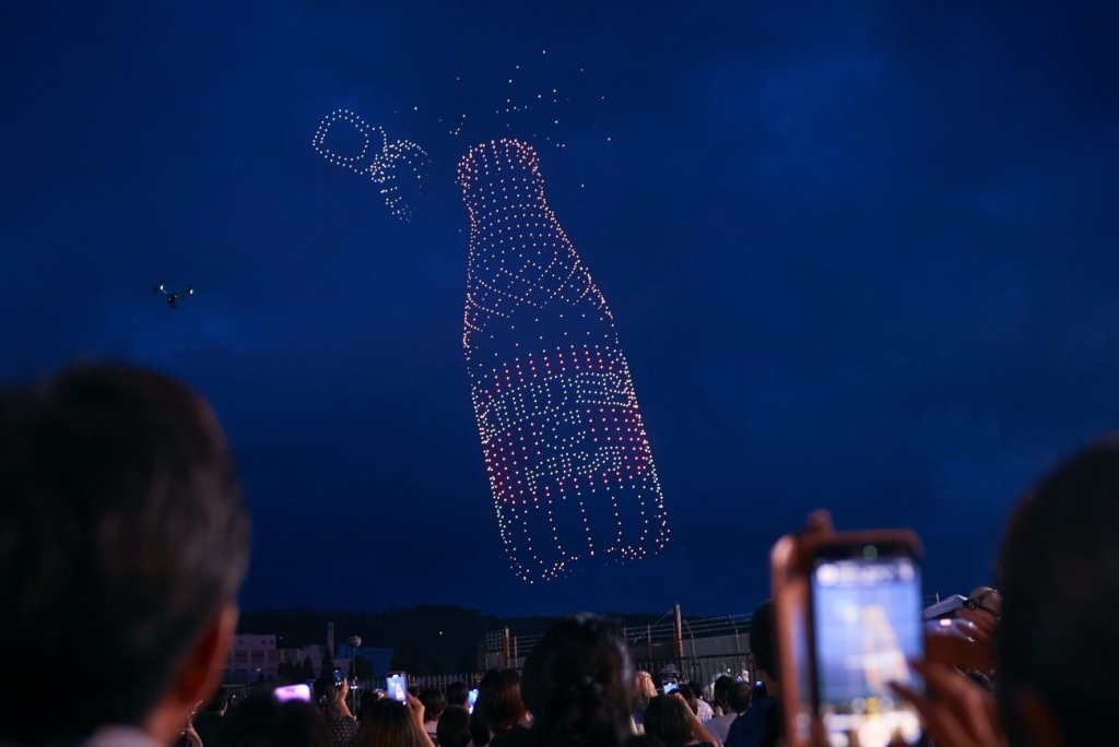 夜空に浮かび上がるオロナミンCドリンク