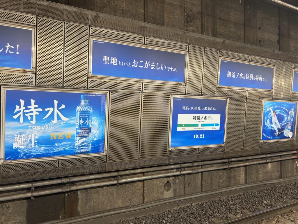 御茶ノ水駅に掲出された「特水」の交通広告、「御茶ノ水は特別な場所です」などのメッセージも