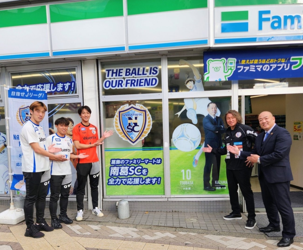 ファミリーマート×「南葛SC」パートナー契約 ファミリーマート水野氏(左)と岡野氏(右から二番目)と選手たち
