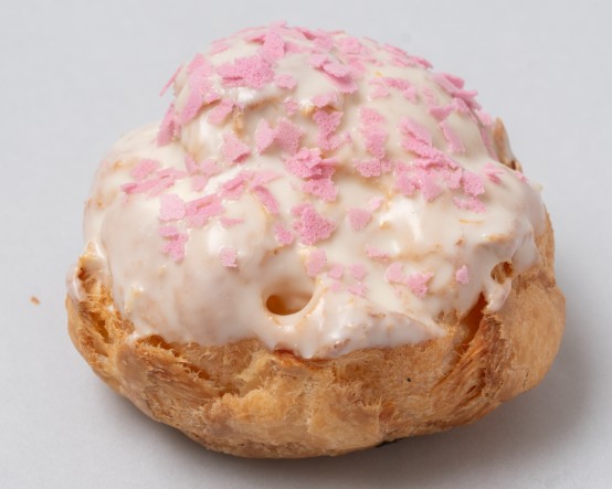 ホワイトチョコでコーティングしたパイシュー生地に桜色フレークをトッピング