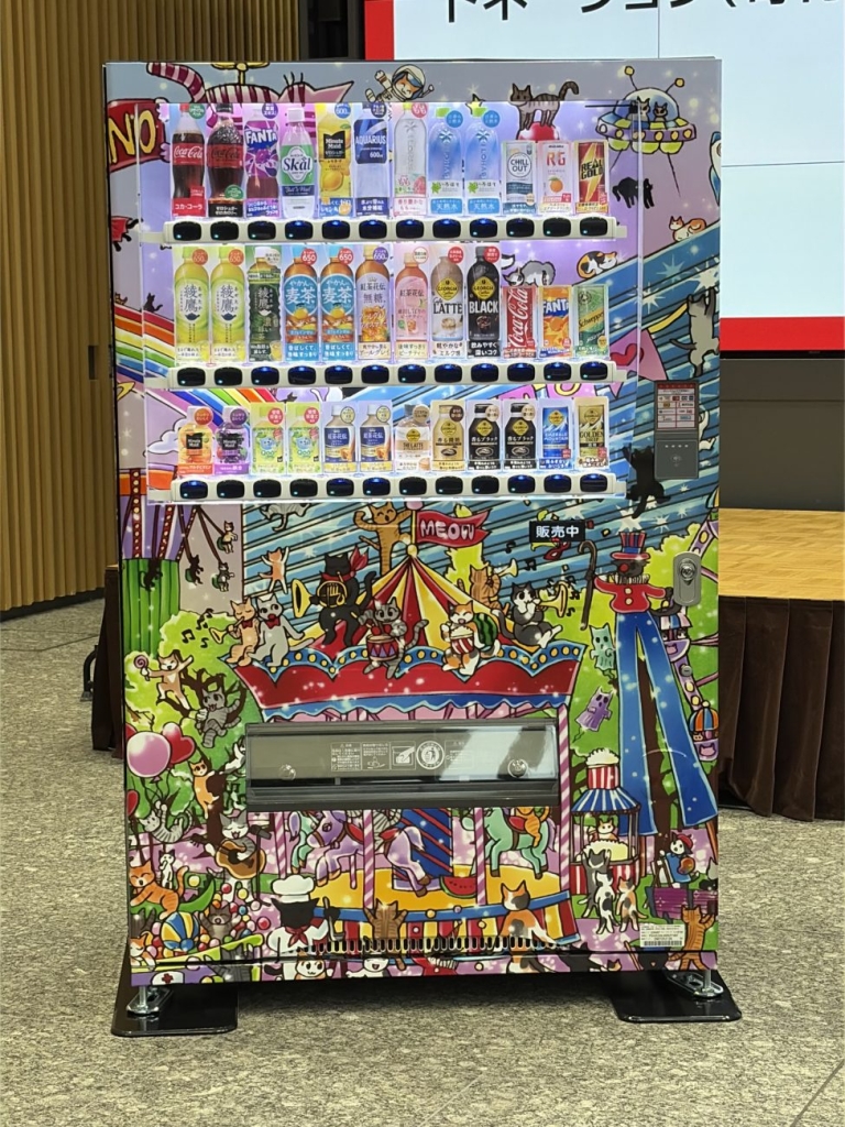 中川翔子さんがラッピングをデザインしたオリジナル自販機、中野四季の森公園の空想の遊園地で楽しむ猫たちを描いた
