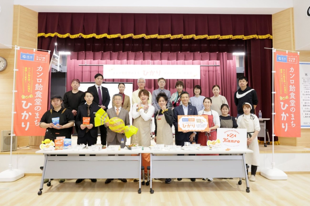 写真下段中央左から、光市芳岡市長、ぺこぱ シュウペイさん･松陰寺さん、カンロ村田社長と参画事業者のみなさん