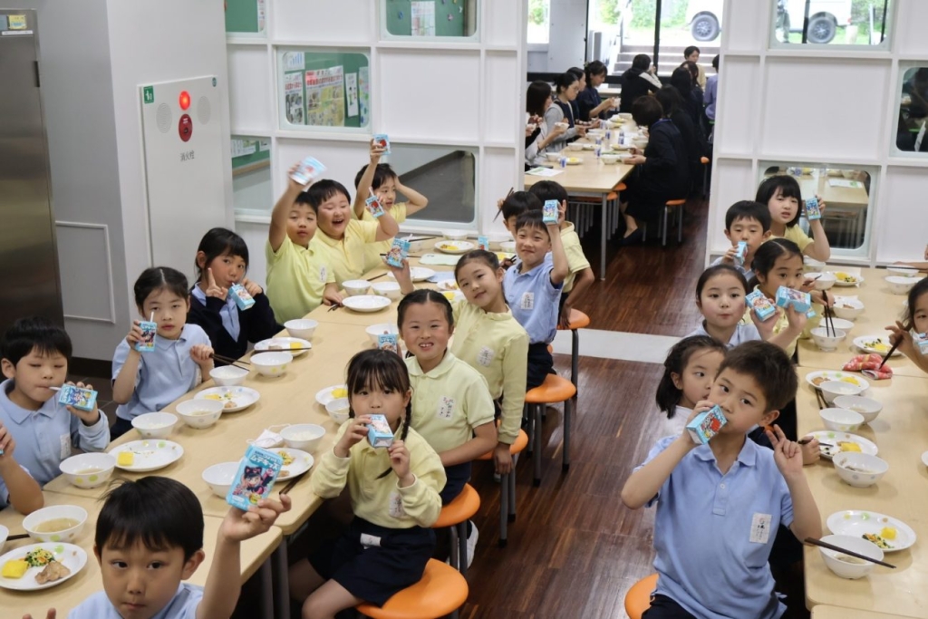 成蹊小学校の給食時間の様子。「キリン つよいぞ！ムテキッズ」を手にする児童たち