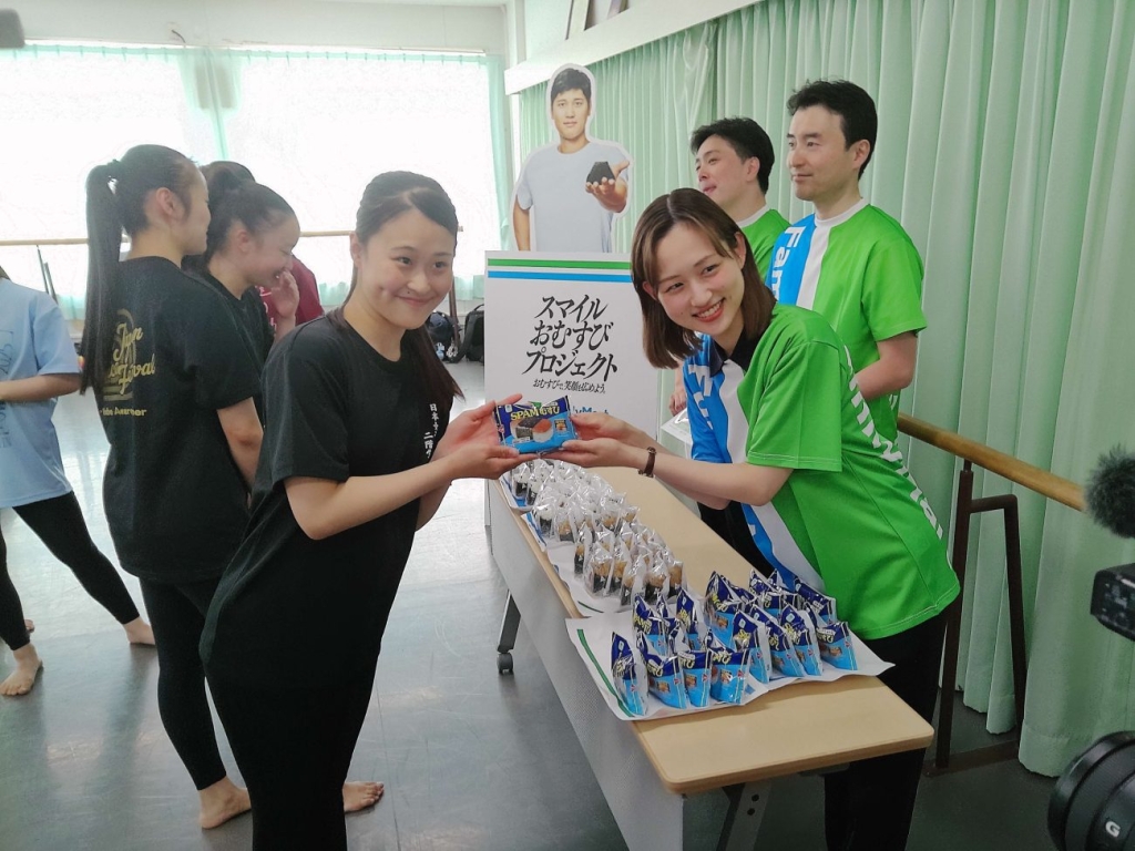 ファミリーマート社員がおむすびを手渡した