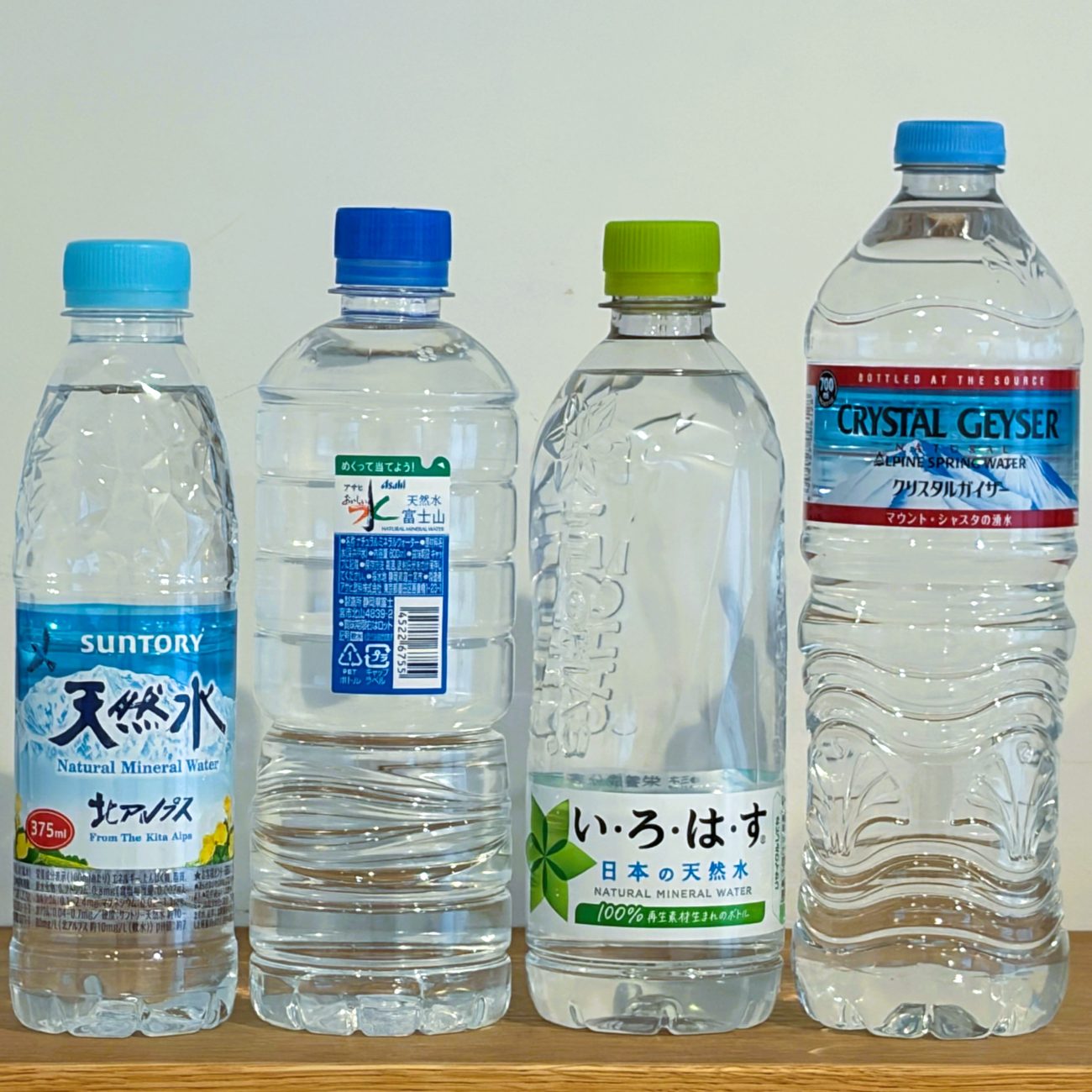各社の製品（左から）「サントリー天然水 375ml」「アサヒ飲料 おいしい水 天然水 シンプルecoラベル 600ml」「い・ろ・は・す 540ml」「クリスタルガイザー 700ml」