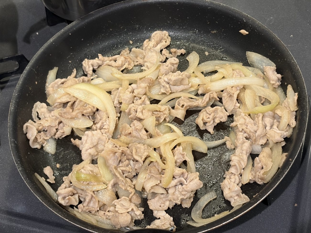 冷蔵庫などで解凍した肉を、野菜とともにフライパンで加熱する