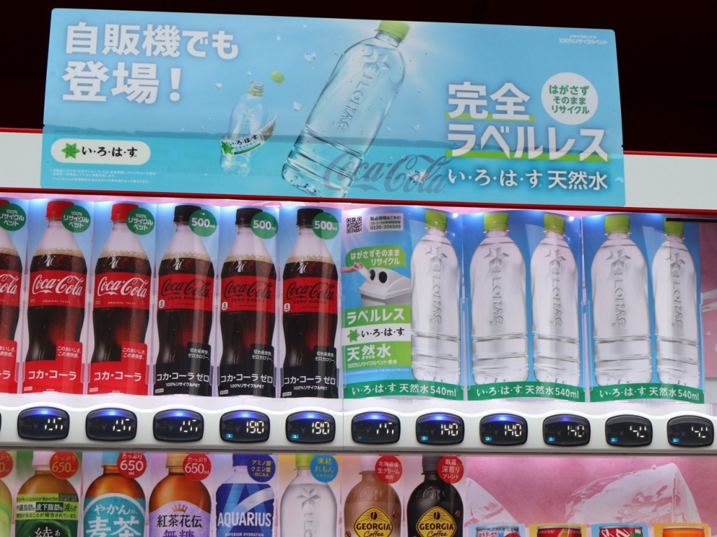 購入前にラベルレス商品とわかるように専用の商品見本を使用、自販機上部の表示でも伝える