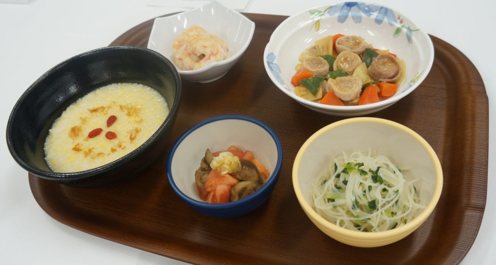 厚生労働省医政局長賞を受賞したニッコクトラストの夕食メニュー(たまご中華がゆや豚もも肉のやわらかロール酢豚など)