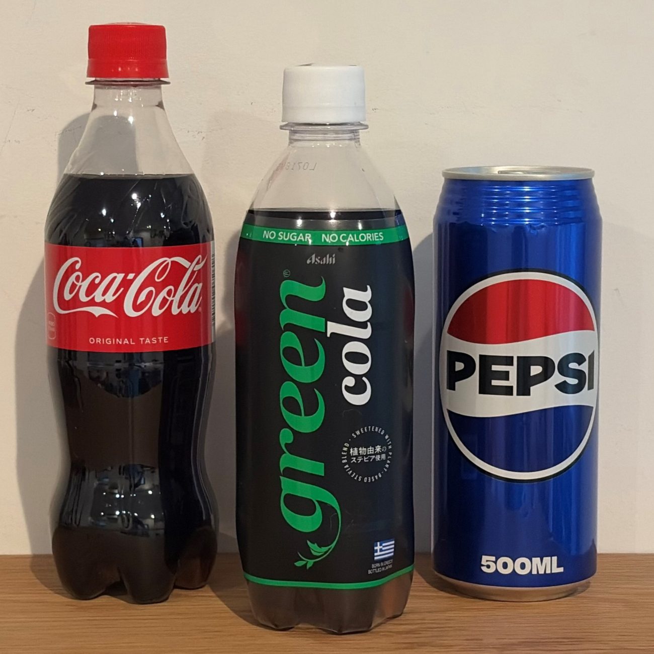 左から「コカ・コーラ」「green cola」「ペプシコーラ」。コーラ市場ではブランドカラーや商品コンセプトによる差別化が続いてきた