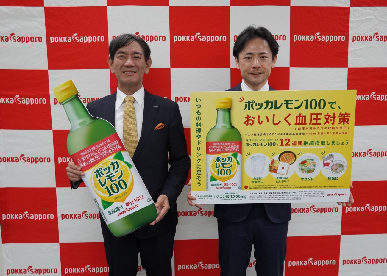 「ポッカレモン100」を手にする佐藤雅志社長（左）と肥後亮氏