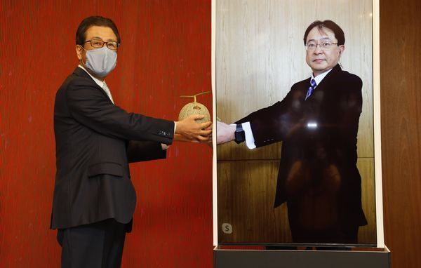 左＝秋元克広札幌市長、右＝オンラインで贈呈式に参加したポッカサッポロフード＆ビバレッジ征矢社長