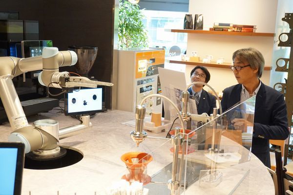 「&robot cafe system」について説明するQBIT・中野社長(右)